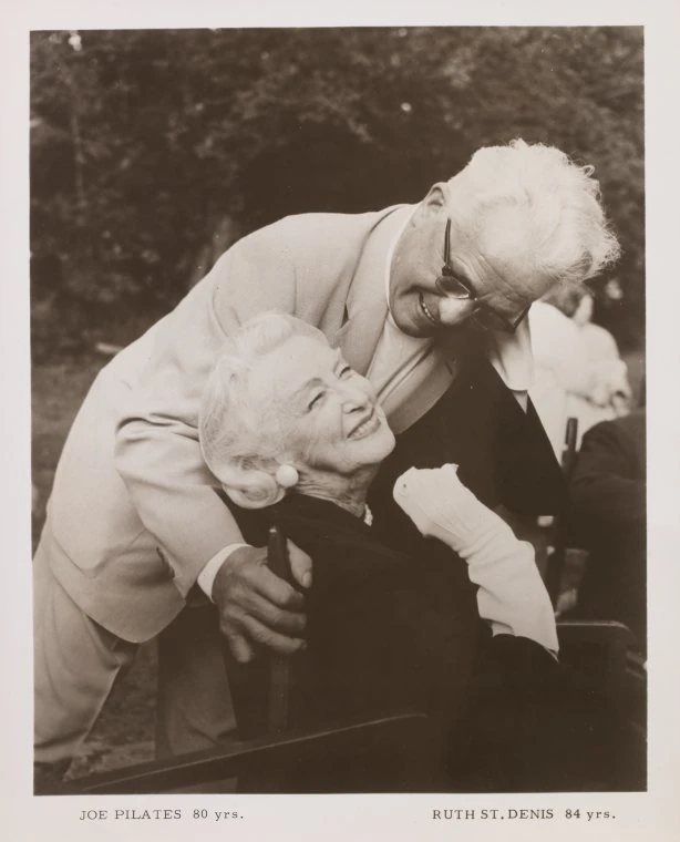 Joseph Pilates, age 80, embracing his client and friend Ruth St. Denis, age 84, the modern-dance pioneer